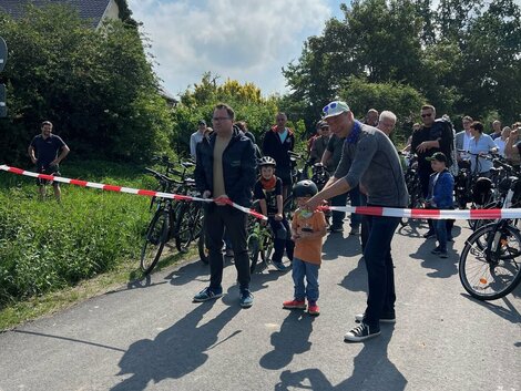 Landrat schneidet Bauabsperrband durch. Symbolisches Bild für die Freigabe des Radweges