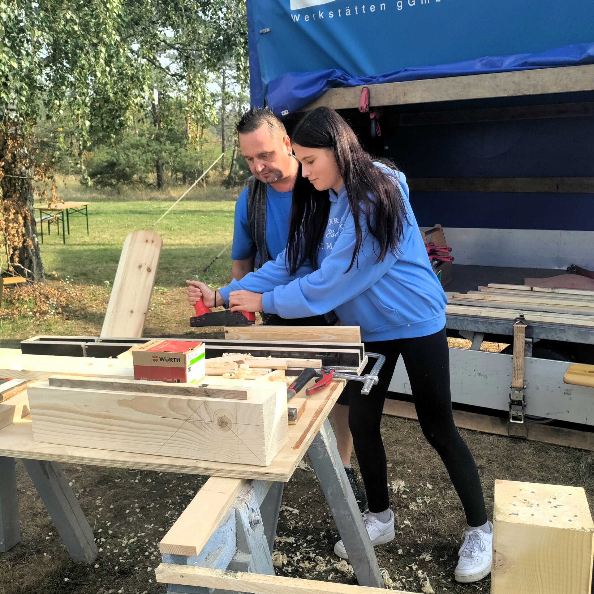 Handwerker und Mädchen bei der Holzbearbeitung