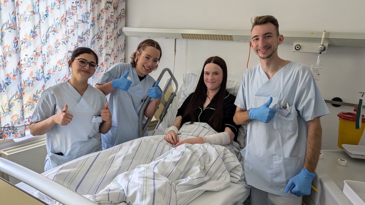 Vier Personen an einem Krankenbett